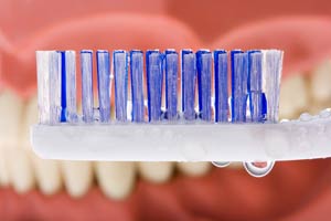 a close-up of a toothbrush being held in front of teeth