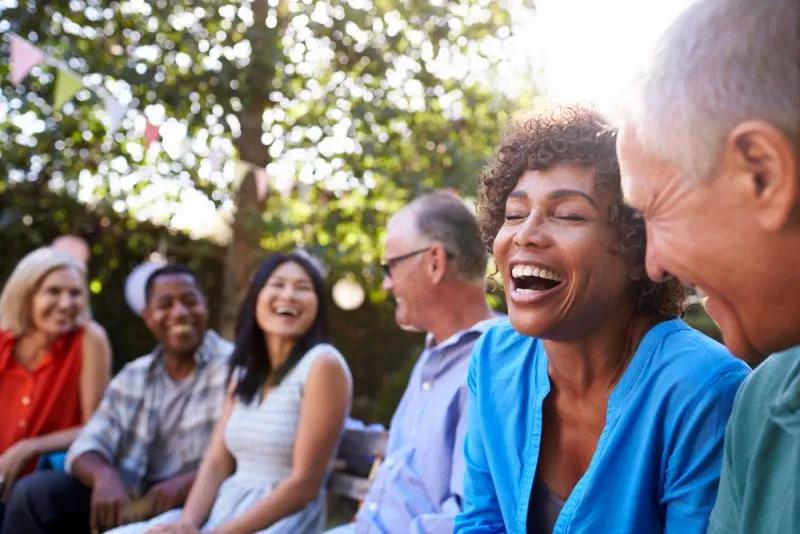 group of friends sitting outside and laughing with each other